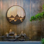 Luminária de parede escultural em aço com iluminação LED suave para exteriors contemporâneos.
