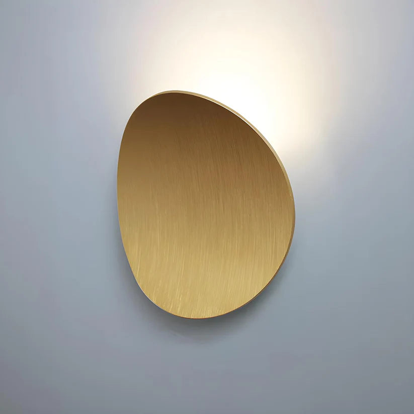 Luminária de parede escultural em metal com iluminação suave e difusa, ideal para ambientes contemporâneos e sofisticados. Dourado