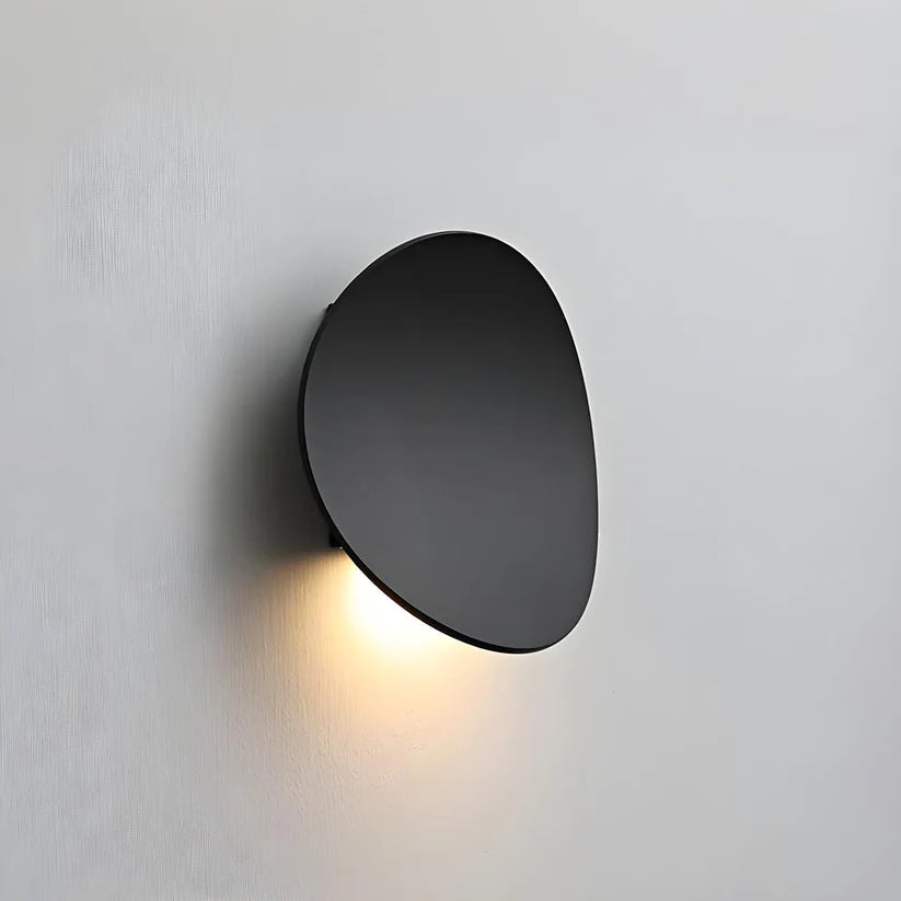 Luminária de parede escultural em metal com iluminação suave e difusa, ideal para ambientes contemporâneos e sofisticados. Preto