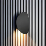 Luminária de parede escultural em metal com iluminação suave e difusa, ideal para ambientes contemporâneos e sofisticados.