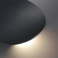 Luminária de parede escultural em metal com iluminação suave e difusa, ideal para ambientes contemporâneos e sofisticados.