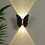 Luminária de parede externa em formato de borboleta, transmitindo um toque de charme contemporâneo e iluminação suave e envolvente. Preto