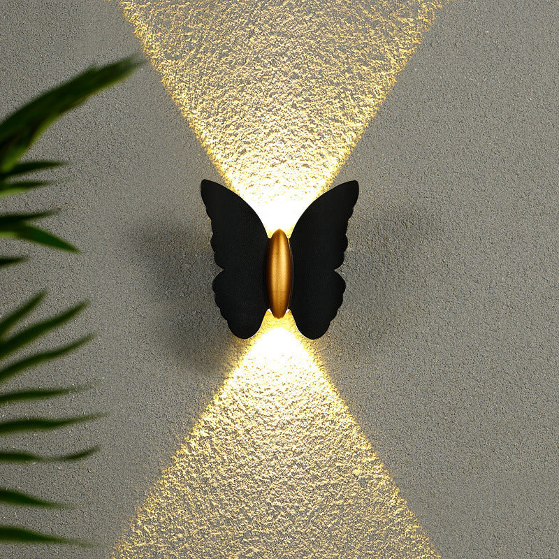 Luminária de parede externa em formato de borboleta, transmitindo um toque de charme contemporâneo e iluminação suave e envolvente. Preto