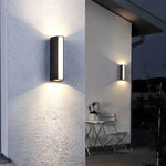 Luminária de parede externa moderna com iluminação bidirecional e design minimalista para ambientes sofisticados.