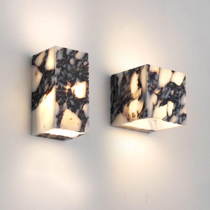 Luminária de parede sofisticada em mármore polido, ideal para iluminar ambientes modernos com um toque de elegância atemporal.