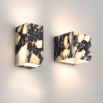 Luminária de parede sofisticada em mármore polido, ideal para iluminar ambientes modernos com um toque de elegância atemporal.