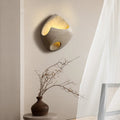 Luminária de parede suave e orgânica, com design inspirado na filosofia Wabi-sabi, que traz uma atmosfera de serenidade e beleza imperfeita ao seu espaço.