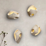 Luminária de parede suave e orgânica, com design inspirado na filosofia Wabi-sabi, que traz uma atmosfera de serenidade e beleza imperfeita ao seu espaço.