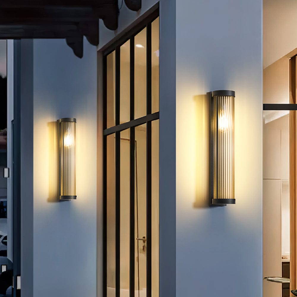 Luminária externa cilíndrica de metal e vidro, resistente à água IP65 com design moderno.