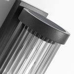 Luminária externa cilíndrica de metal e vidro, resistente à água IP65 com design moderno.