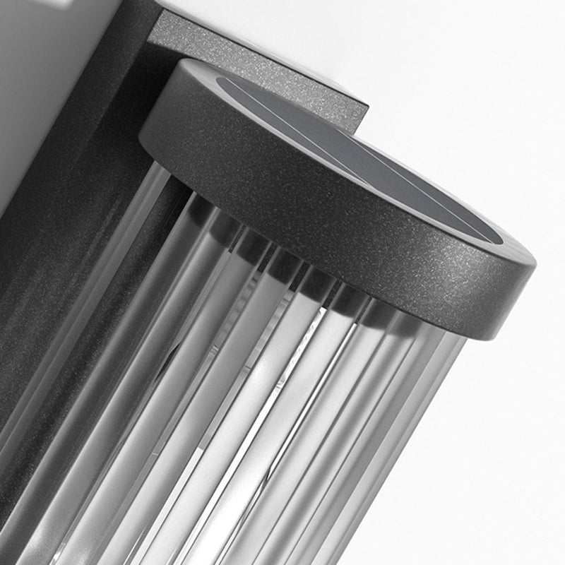 Luminária externa cilíndrica de metal e vidro, resistente à água IP65 com design moderno.