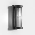 Luminária externa cilíndrica de metal e vidro, resistente à água IP65 com design moderno.